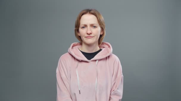 Video van jonge verwarde vrouw in roze sweatshirt - Video