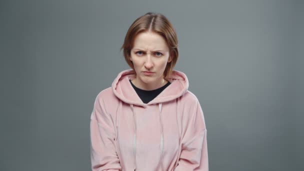 Video of young gloomy woman in pink sweatshirt - Footage, Video