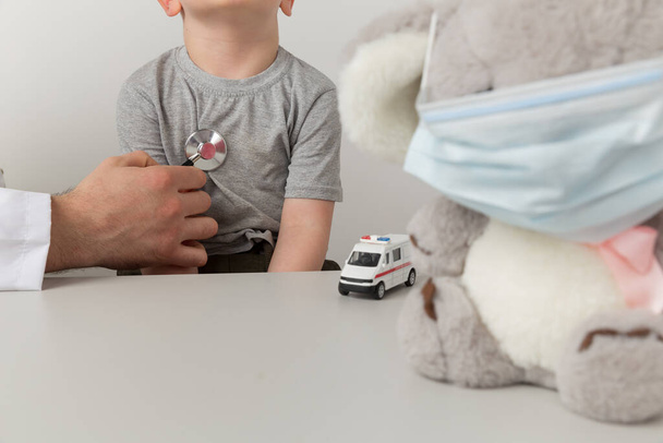Man kinderarts met kind speelgoed met behulp van stethoscoop in de kast. - Foto, afbeelding