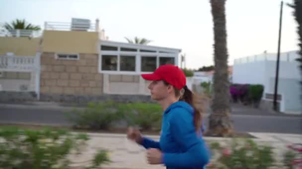 A mulher corre pela rua. Estilo de vida ativo saudável. Vista lateral
 - Filmagem, Vídeo