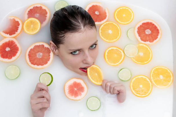 Portrait of a girl with fruit in a bath - Photo, Image