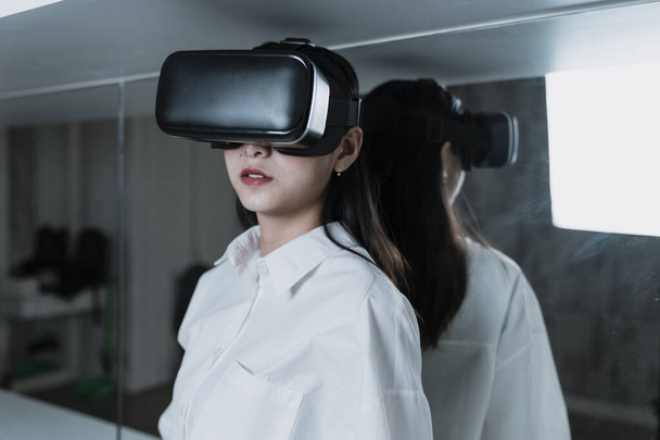 Довге волосся жінка в білій сорочці з чорною машиною VR для технології
. - Фото, зображення