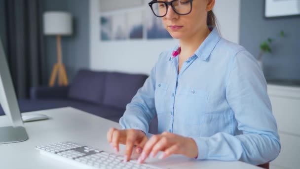 Femme à lunettes tapant sur un clavier d'ordinateur. Concept de télétravail. - Séquence, vidéo