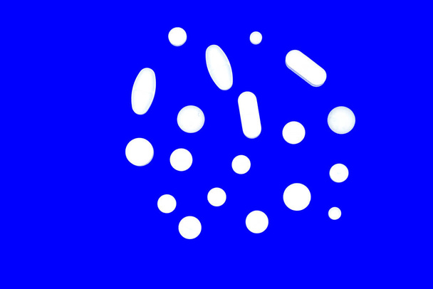 píldoras farmacéuticas blancas sobre fondo azul
 - Foto, Imagen