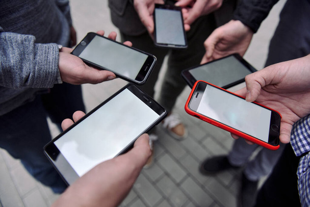 Close-up image of young men group hands  using smartphone on the sreet city - Photo, Image