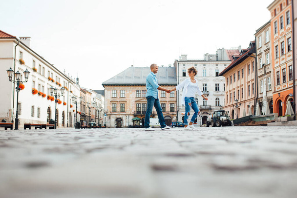ragazzo e una ragazza camminano felicemente al mattino per le strade vuote della vecchia Europa
 - Foto, immagini