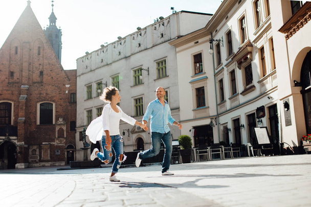 guy and a girl happily walk in the morning on the empty streets of old Europe - Φωτογραφία, εικόνα