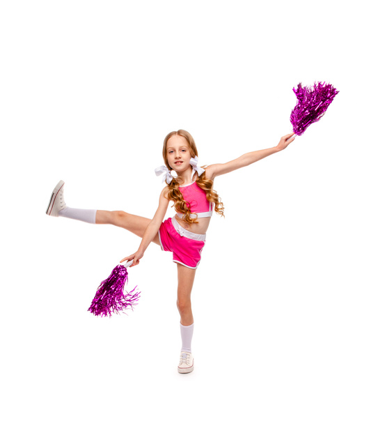 lang haar meisje in een roze top en cheerleader kleding dansen met pompons - Foto, afbeelding