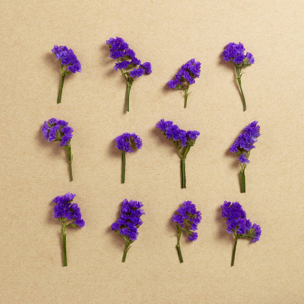 Lila statice virágok kraft papír háttér. Virágkompozíció, lapos fektetés, felülnézet, másolás - Fotó, kép