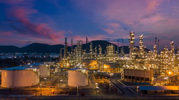 Olieraffinaderij met olietank en petrochemische fabriek industriële achtergrond bij schemering, luchtfoto olie- en gasraffinaderij bij schemering. - Foto, afbeelding