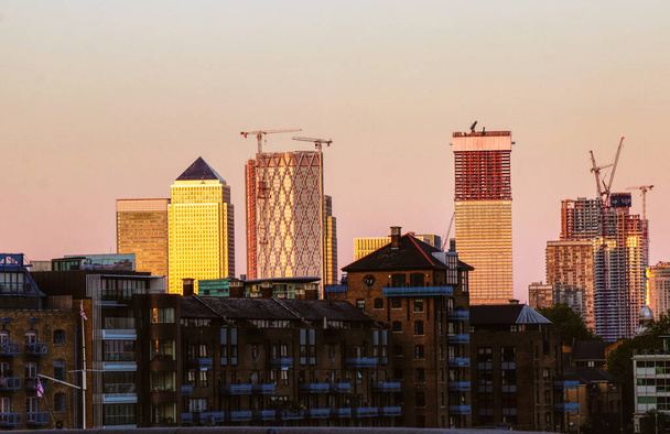 Arranha-céus de Londres durante o pôr-do-sol da ponte Tower. Vista para Whitechapel, St. George, na parte leste de Londres, Reino Unido. Edifícios modernos no século 21. Última arquitetura
. - Foto, Imagem