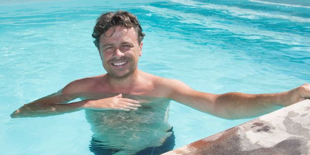 Красивый мужчина расслабляется в доме бассейн в отпуске в доме
 - Фото, изображение