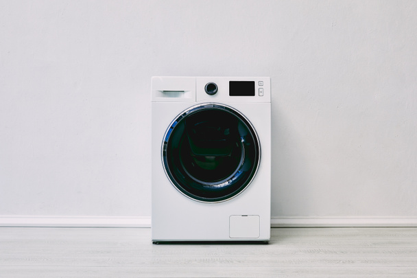 modern washing machine near white wall in bathroom  - Foto, afbeelding