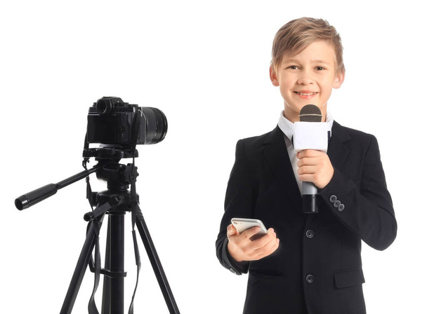 Mały dziennikarz z mikrofonem, telefonem komórkowym i kamerą na białym tle - Zdjęcie, obraz