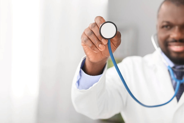 Male African-American doctor with stethoscope in clinic, closeup - Foto, Imagem