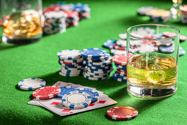 Green gambling table with whisky and cards - Foto, imagen