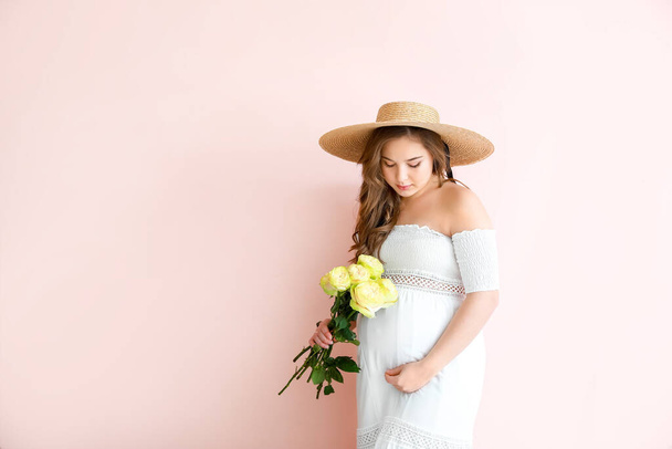 Красивая беременная женщина с цветами на фоне
 - Фото, изображение