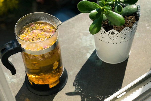 Горячая медицина травяные ромашки цветы желтый чай во французском чайнике пресса  - Фото, изображение
