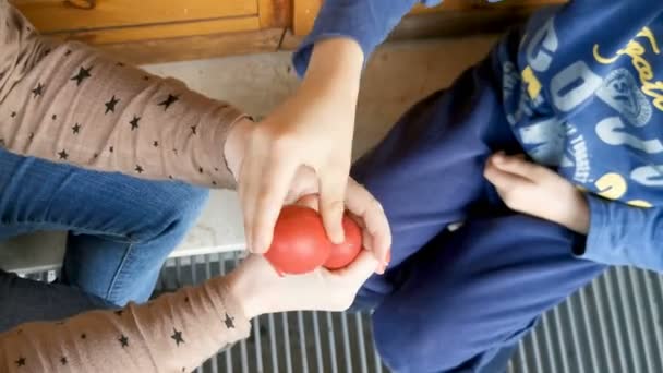 древняя традиционная пасхальная игра Реджо Эмилия с цветными вареными яйцами cocetto сделаны между матерью и ребенком - Кадры, видео
