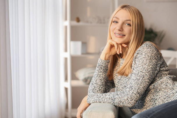 Young woman with dental braces at home - Valokuva, kuva