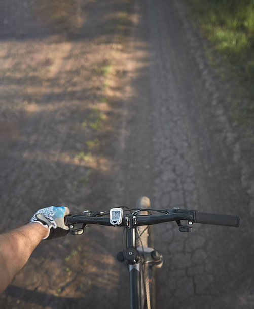 Un homme en vélo. tenir le guidon de vélo avec une main dans le gant de sport. activité sportive estivale de plein air. vue à la première personne vélo équitation
 - Photo, image
