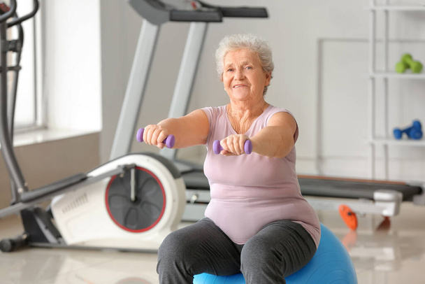 Elderly woman exercising in gym - Photo, Image