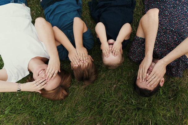 Portrétní rodina s dětmi ležícími na trávě - Fotografie, Obrázek