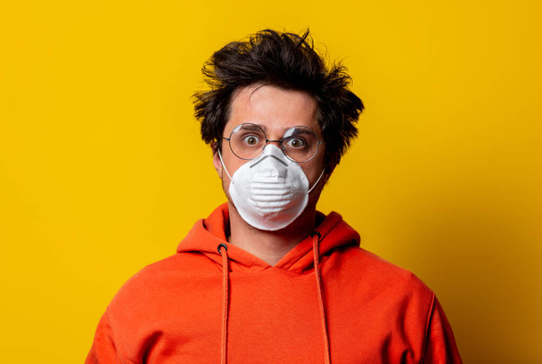 guy in face mask and glasses with tousled hair on yellow background - Photo, Image