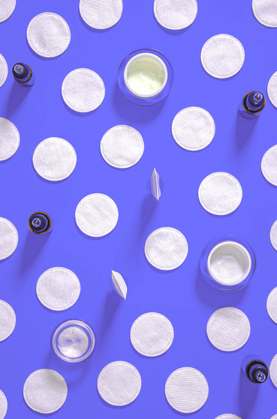 Προϊόντα υγιεινής: λευκά στρογγυλά βαμβακερά μαξιλάρια και πλαστικά sticks για τον καθαρισμό των αυτιών βρίσκονται σε μπλε φόντο δίπλα στην κρέμα προσώπου. Πάνω άποψη, επίπεδη lay - Φωτογραφία, εικόνα