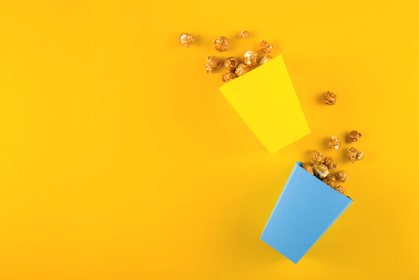 Popcorn für Heimkino auf gelbem Hintergrund. Ansicht von oben - Foto, Bild