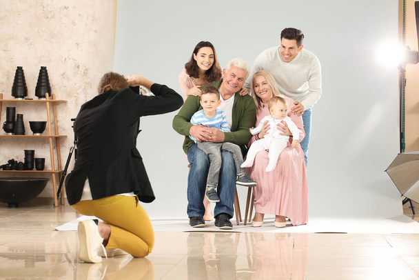 Фотограф, работающий с семьей в студии
 - Фото, изображение