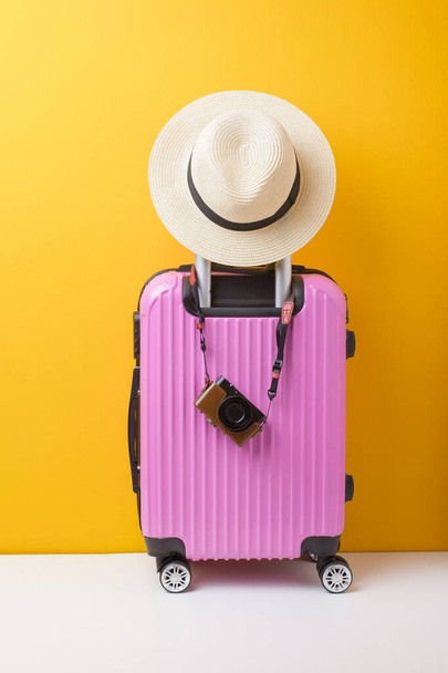 Pink baggage on yellow background, travel concept  - Φωτογραφία, εικόνα