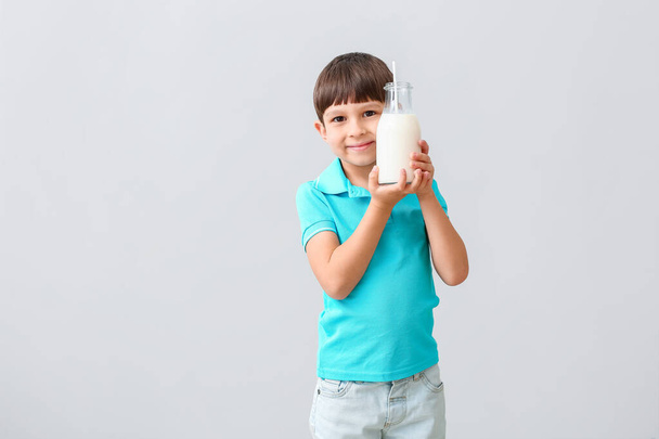 Niño pequeño con leche sobre fondo claro
 - Foto, imagen