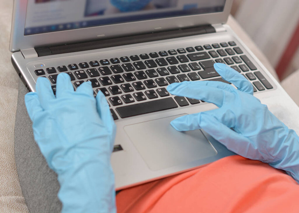 рука в синей резиновой перчатке, работающей в ноутбуке
 - Фото, изображение