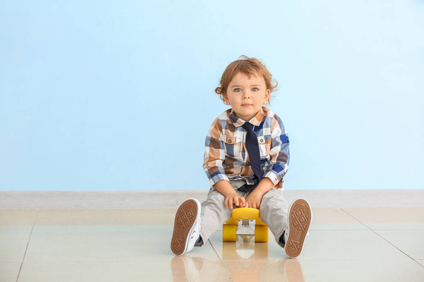 Cute little boy with skateboard near color wall - Zdjęcie, obraz