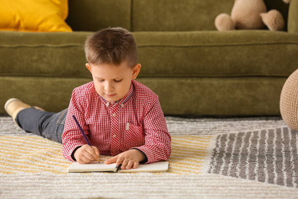 Cute little boy with notebook at home - Φωτογραφία, εικόνα