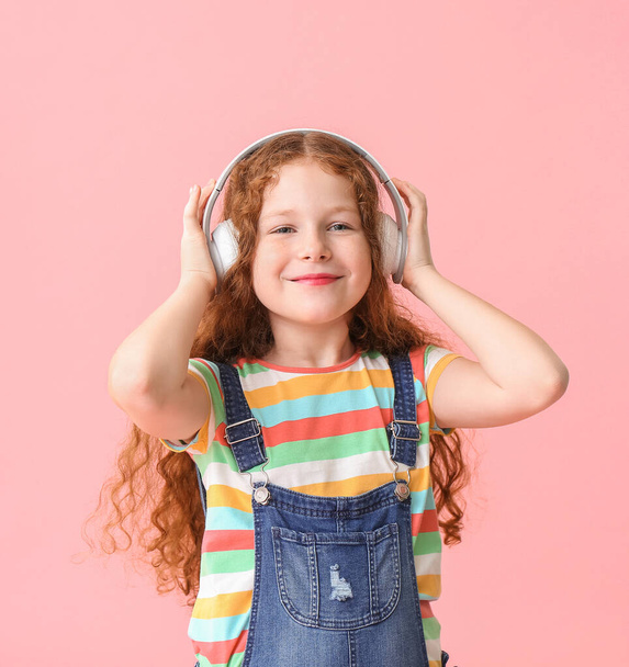 Cute little girl listening to music on color background - Foto, Imagen