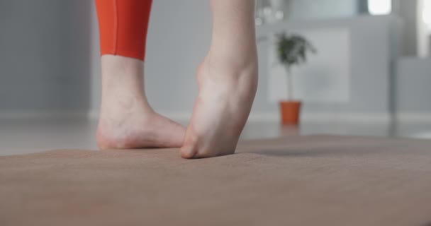 Woman warms up and stretches her feet at the yoga class in slow motion, person makes physical exercises, stretching and gymnastics, 4k DCI 60p Prores HQ - Video