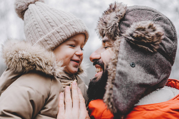 Handsome young dad and his little sweet daughter have fun outdoors in winter. Happy family spending time together. Family concept. - Фото, изображение