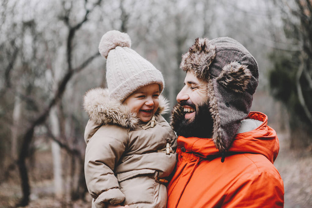 Handsome young dad and his little sweet daughter have fun outdoors in winter. Happy family spending time together. Family concept. - Foto, Imagen