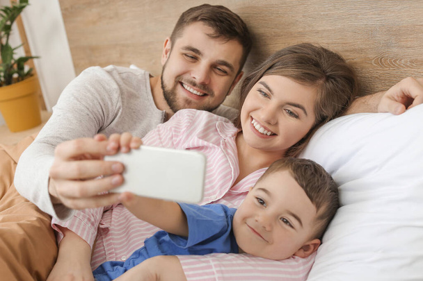 Mutlu aile portresi yatak odasında selfie çekiyor. - Fotoğraf, Görsel