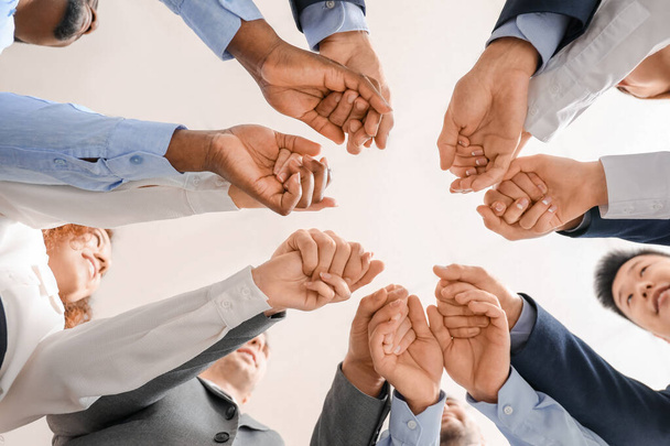 Grupo de gente de negocios poniendo las manos juntas en la oficina, vista inferior. Concepto de unidad
 - Foto, Imagen