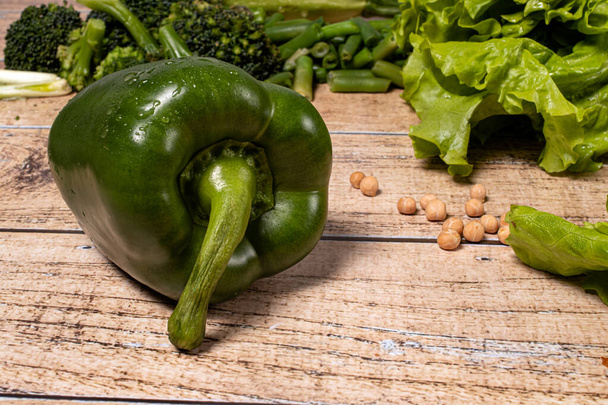 Grüne gesunde Paprika auf braunem Holzgrund. Produkte für die Keto-Diät, glutenfreie Ernährung und richtige Ernährung zur Gewichtsabnahme. - Foto, Bild