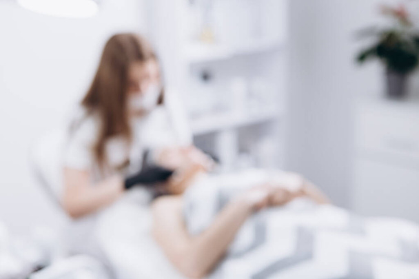 blurred photo of a spa where a doctor performs a procedure on a woman lying on the bed. Copy space - Valokuva, kuva