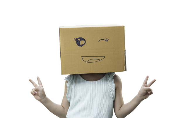 Κοριτσάκι που φοράει χαρτόκουτο στο κεφάλι με χαμογελαστό πρόσωπο, απομονωμένο σε λευκό φόντο. - Φωτογραφία, εικόνα