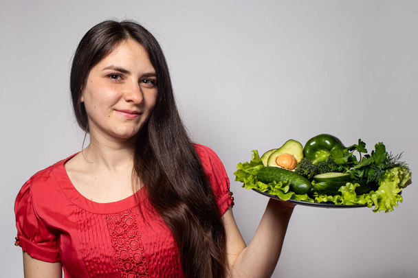 Girl and a vegetable plate. Veganism and vegetarianism. Proper nutrition, raw food diet and vegetable diets. Weight Loss with Ketodiet, Gluten Free Nutrition. - Photo, Image