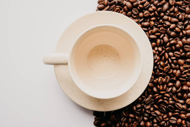 An emty white coffee cup with coffee beans and a white background - Fotografie, Obrázek