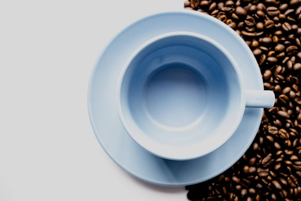 An emty white coffee cup with coffee beans and a white background - Fotografie, Obrázek