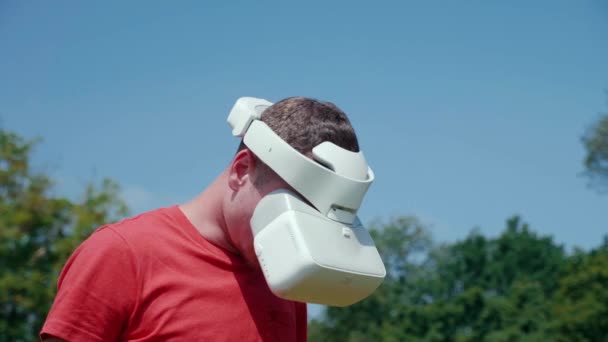 Um homem em um capacete realidade virtual abaixa a cabeça para baixo
 - Filmagem, Vídeo