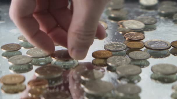 Αρσενικό χέρι συλλογή νομισμάτων κάτω από το νερό και δημιουργώντας φυσαλίδες. Αργή κίνηση - Πλάνα, βίντεο